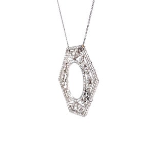 May include: A silver necklace with a hexagonal pendant encrusted with small, clear gemstones. The pendant is open in the center, creating a circular shape.