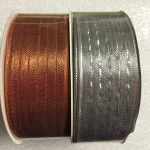 K&ouml;nnte beinhalten: Zwei Rollen Band, eine kupferfarben und eine silberfarben, mit schimmerndem Finish.