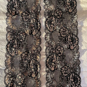 May include: Two pieces of black and silver lace trim with a floral pattern.