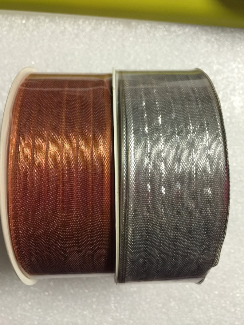 K&ouml;nnte beinhalten: Zwei Rollen Band, eine kupferfarben und eine silberfarben, mit schimmerndem Finish.