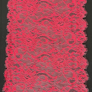 May include: Red lace trim with a floral pattern. The lace has a scalloped edge.