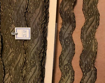 Puede incluir: Tres carretes de ribete estampado en dorado y verde con borde festoneado. El ribete está etiquetado como "1.0y".