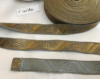 Puede incluir: Tres piezas de ribete con estampado dorado y plateado, cada una de 2,5 cm de ancho. El ribete tiene un diseño geométrico con un patrón ondulado.