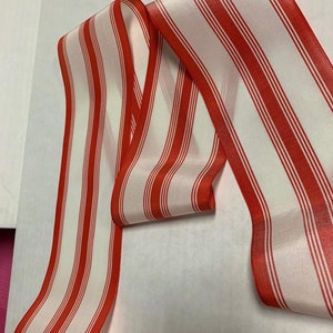 May include: Red and white striped ribbon with a satin finish.