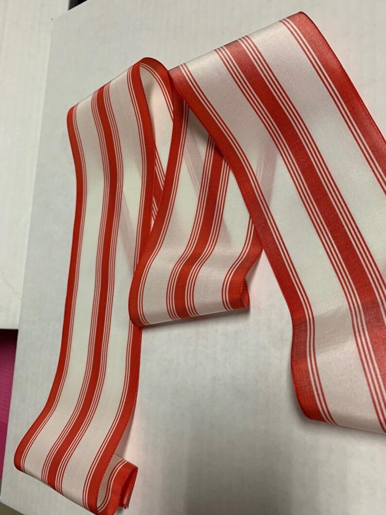 May include: Red and white striped ribbon with a satin finish.