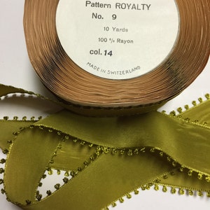 May include: A spool of green rayon ribbon with a picot edge. The label reads "Picot - St. Moritz Yarn Dyed Pattern Royalty No. 9 10 Yards 100% Rayon col. 14 Made in Switzerland".