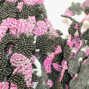 Kralenrand. Versieringen, poppenversieringen, kostuums, woondecoratie, motieven. Op maat gesneden geprijsd. Kleur fuchsia/zwart