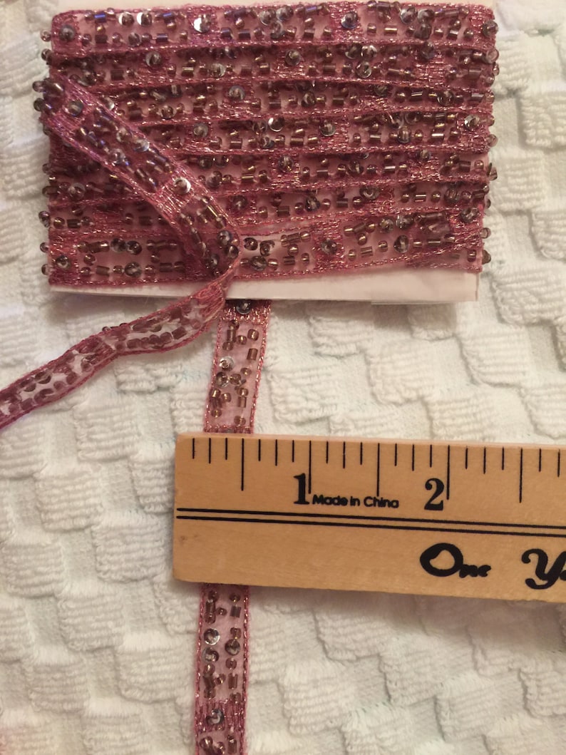 Pode incluir: Bordado de contas rosa com lantejoulas, medindo 2,5 cm de comprimento. Feito na China.