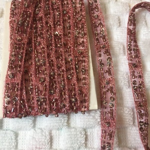 Pode incluir: Bordado de contas rosa com uma base de tecido transparente. O bordado &eacute; feito de pequenas contas redondas e tem um visual delicado e feminino.