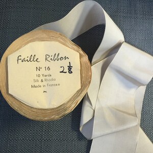 May include: A spool of white faille ribbon with a label that reads "Faille Ribbon N° 16 28¢ 10 Yards Silk & Rhodia Made in France".