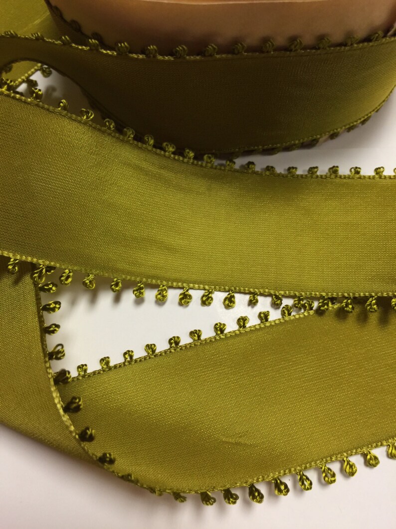 May include: Olive green satin ribbon with a scalloped edge and small pom-poms along the edge.
