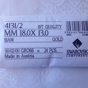 May include: A white paper bag with the text "4131/2 IST QUALITY MM 18,0X 13,0 SIAM GOLD 00/02/00 GROSS = 24 PCS. Made in Austria" and a Swarovski logo with the text "SWAROVSKI COMPONENTS".