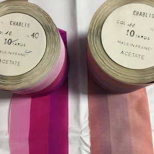Puede incluir: Dos carretes de cinta rayada rosa, roja y morada. Los carretes est&aacute;n etiquetados con "Chablis" y tienen el texto "Col 41 N 40 10 Yards Made in France Acetate".