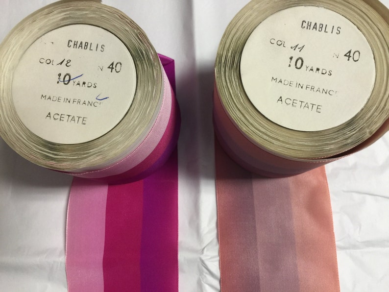 Puede incluir: Dos carretes de cinta rayada rosa, roja y morada. Los carretes est&aacute;n etiquetados con "Chablis" y tienen el texto "Col 41 N 40 10 Yards Made in France Acetate".