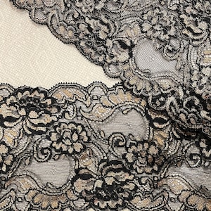 May include: Black and gold lace trim with a floral pattern.