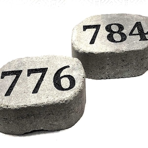 May include: Two gray concrete house numbers, one with the number 776 and the other with the number 784.