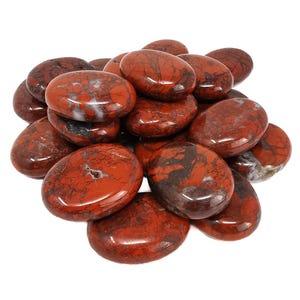 Puede incluir: Un montón de piedras de jaspe lisas, rojas y negras. Las piedras tienen forma ovalada y un acabado pulido.