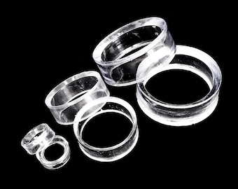 May include: A set of five clear plastic rings of varying sizes. The rings are stacked on top of each other.