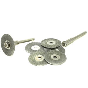 Puede incluir: Un juego de seis pequeños discos de corte de diamante para usar con una herramienta rotativa. Los discos son plateados y tienen una textura rugosa. El juego también incluye un mandril de metal plateado con una cabeza de tornillo.