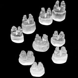 Puede incluir: Diez miniaturas de castillo de cristal transparente, cada una con un diseño único, están dispuestas sobre un fondo negro. Los castillos están hechos de cristal transparente y tienen un acabado esmerilado.