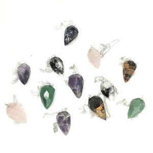 Puede incluir: Surtido de 10 colgantes de cristal en punta en cadenas de plata. Los colgantes son de varios colores, incluyendo amatista, cuarzo rosa, aventurina verde, ojo de tigre y obsidiana negra.