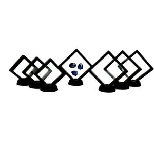 Könnte beinhalten: Ein Satz von acht schwarzen Präsentationsboxen mit klaren Plastikfenstern, die für die Präsentation kleiner Gegenstände wie Edelsteine oder Schmuckstücke konzipiert sind. Die Boxen sind in einer Reihe angeordnet, wobei die mittlere Box drei blaue Edelsteine zeigt.