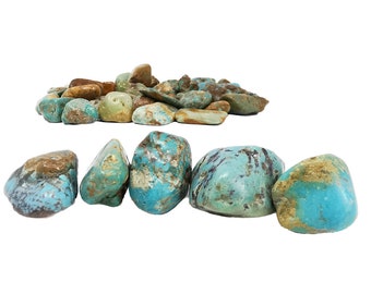 Può includere: Una collezione di pietre turchesi in varie tonalità di blu e verde. Le pietre sono lisce e levigate, con un aspetto naturale e terroso.