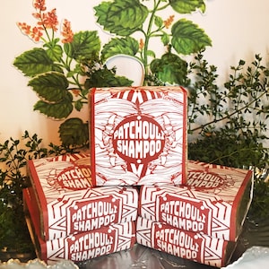 May include: A stack of five brown bars of soap with white labels. The labels have a black and white illustration of a plant and the text "Patchouli Shampoo".