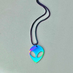 May include: A silver chain necklace with an iridescent blue alien head pendant.