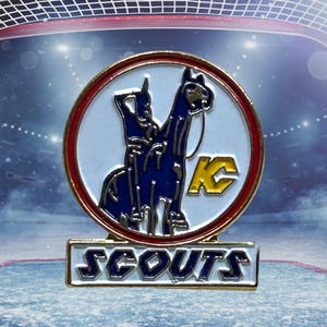 Puede incluir: Pin redondo con borde dorado, con un dise&ntilde;o de caballo y jinete azul sobre fondo blanco, con un logotipo "KC" amarillo. La palabra "SCOUTS" se muestra en letras doradas sobre una base rectangular.