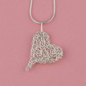 May include: A silver chain necklace with a heart-shaped pendant made of woven silver wire.