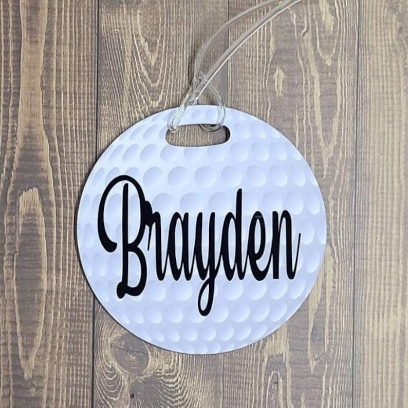 Peut inclure: Etiquette &agrave; bagages en forme de balle de golf blanche avec le nom "Brayden" imprim&eacute; en noir.