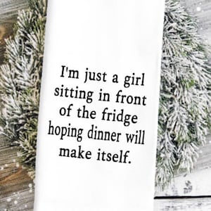 May include: White kitchen towel with black text that reads "I'm just a girl sitting in front of the fridge hoping dinner will make itself."
