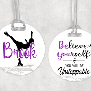 May include: Two round luggage tags with white backgrounds. The left tag features a silhouette of a figure ice skating with the name "Brook" in purple script. The right tag has the text "Believe in yourself & you will be unstoppable" in black and purple script.