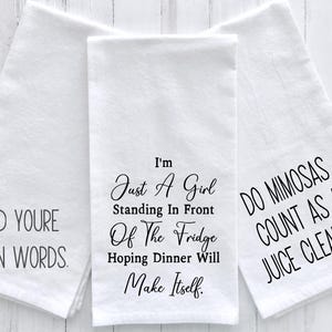 May include: Three white tea towels with black text. The first towel says "Add youre own words." The second towel says "I'm just a girl standing in front of the fridge hoping dinner will make itself." The third towel says "Do mimosas count as a juice cleanse?"