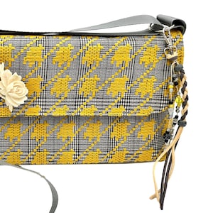 Borsa a tracolla di piccole dimensioni in stile messenger, in tessuto pied de poule in stile retrò, con numerose tasche, nappa a clip, elegante spilla. Unica!