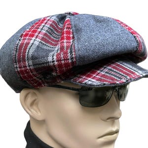 Peut inclure: Une casquette gavroche composée de panneaux gris unis alternés avec des panneaux à motif écossais rouge, noir et blanc. La casquette présente une calotte structurée et une visière courte et rigide assortie au motif écossais des côtés.