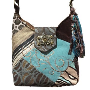 May include: A patchwork shoulder bag with a variety of patterned fabrics in shades of brown, tan, and teal. The bag features a flap with a decorative metal clasp and a tassel with beads. The bag has a brown strap.