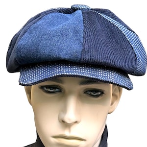May include: A multi-textured newsboy cap featuring panels of dark blue denim, navy blue corduroy, and a blue and white micro-check patterned fabric on the brim and side. The cap has a rounded, structured crown with a button detail at the top center.