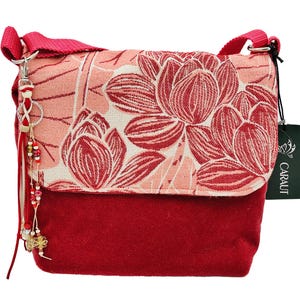 Cartera estilo mensajero cruzada confeccionada con un lujoso tejido de terciopelo rosa salmón y flores tejidas a juego. Borla de cuero con clip.