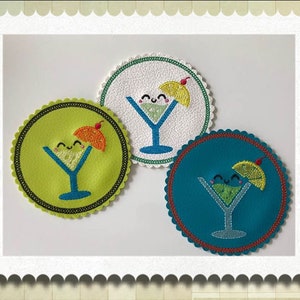 May include: Three round coasters with a scalloped edge. Each coaster features a different color background: green, white, and blue. Each coaster has a smiling cartoon margarita glass with a lime wedge and a cherry on top.