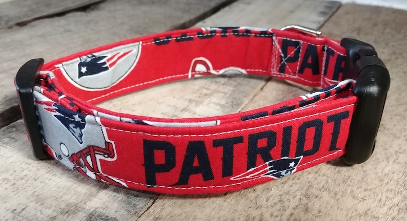 May include: Red, white, and blue dog collar with the word "PATRIOT" printed in black. The collar features a repeated pattern of the New England Patriots logo.
