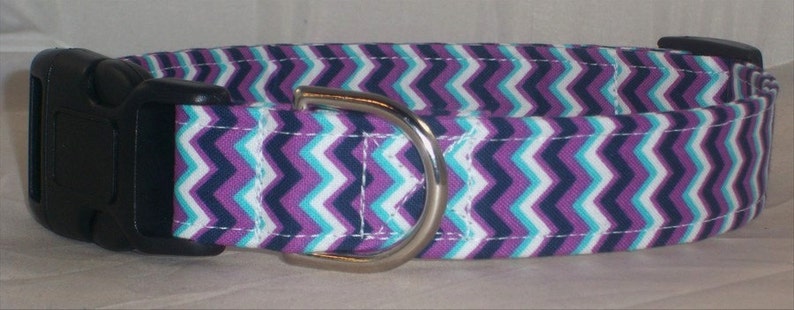 May include: Purple, white, and navy blue chevron patterned dog collar with a silver buckle.