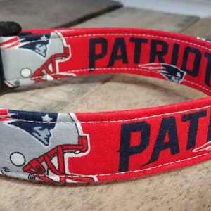 May include: Red, white, and blue dog collar with a Patriots logo and the word "Patriots" printed on it.