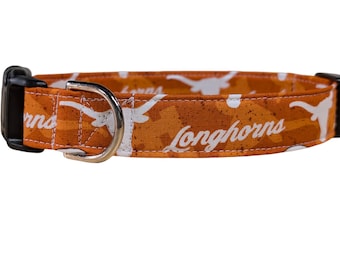 May include: Orange and white dog collar with a white Longhorns logo and a white silhouette of a longhorn steer.