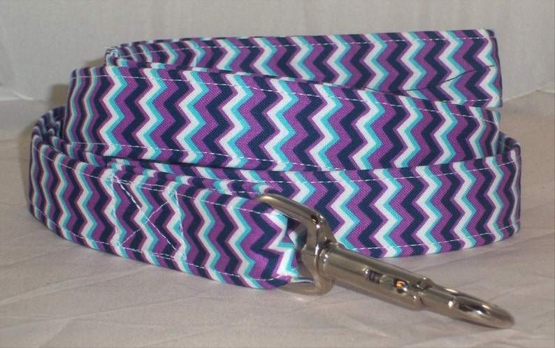 May include: Purple, white, and blue chevron patterned dog leash with a silver clip.