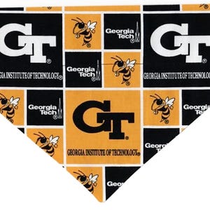 May include: Triangular bandana featuring a repeating pattern of black and gold squares. Each square displays the letters "GT" or a yellow jacket mascot, along with the words "Georgia Institute of Technology" and "Georgia Tech".