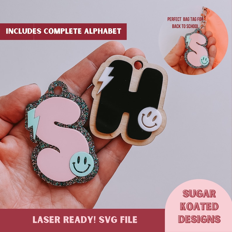 May include: Two laser-cut wooden letters, "H" and "S", with a pink glitter letter "S" in the background. The letters have a lightning bolt and a smiley face design. The letters are labeled "Laser Ready! SVG File" and "Sugar Koated Designs".