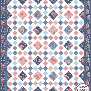 Puede incluir: Un edredón de patchwork con un diseño floral y geométrico. El edredón presenta un fondo blanco con un patrón de cuadrados azules, rosas y florales. El borde es una impresión floral azul oscuro. El texto "BUSY HANDS QUILTS" está en la esquina inferior derecha.