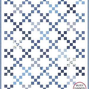 May include: A handmade quilt with a repeating pattern of blue squares in various shades and patterns, including floral, plaid, and solid designs. The quilt has a white background and a blue border. The quilt is labeled "Busy Hands Quilts".